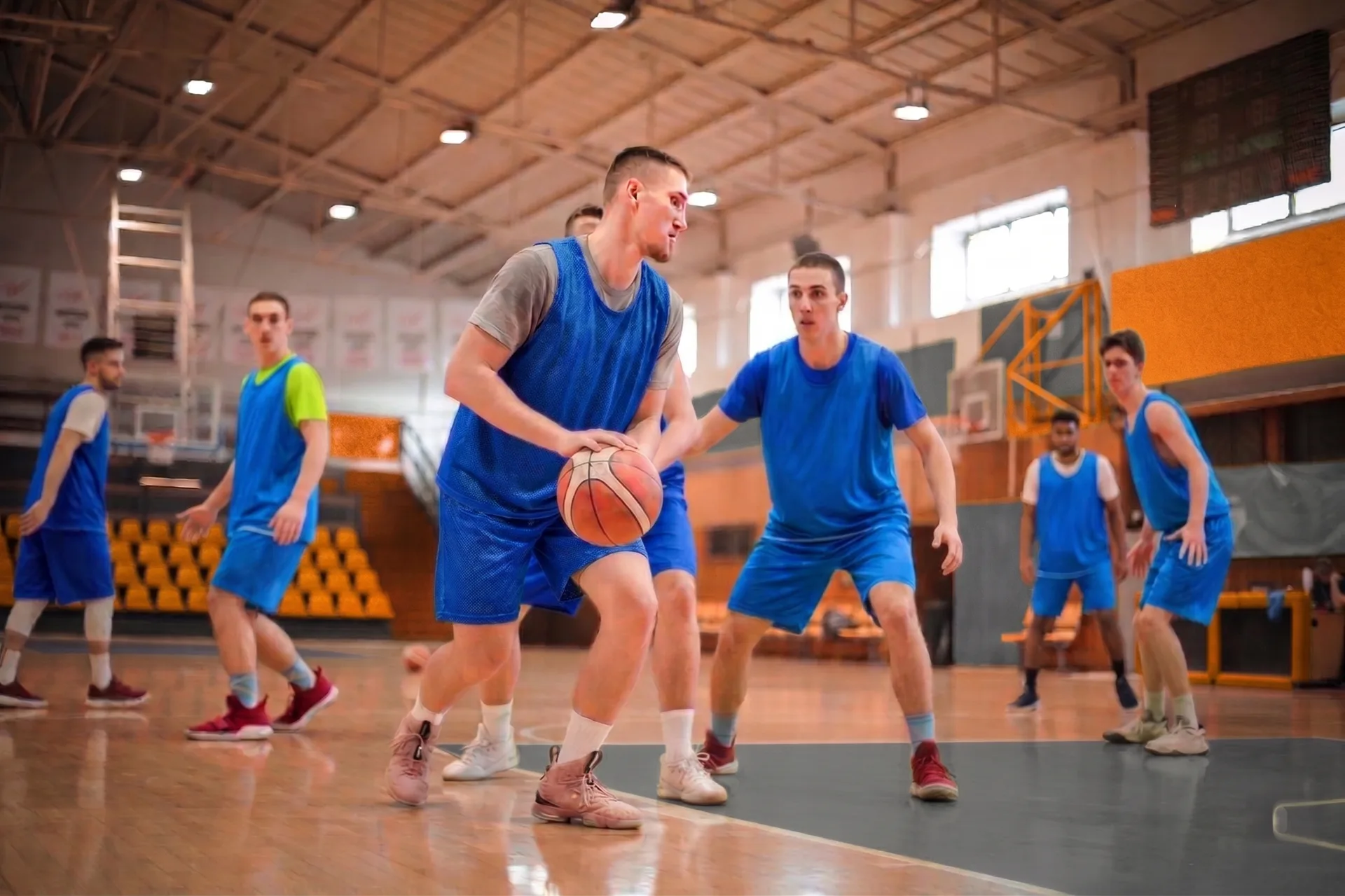 A coach watching a high-school basketball practice in a school gym