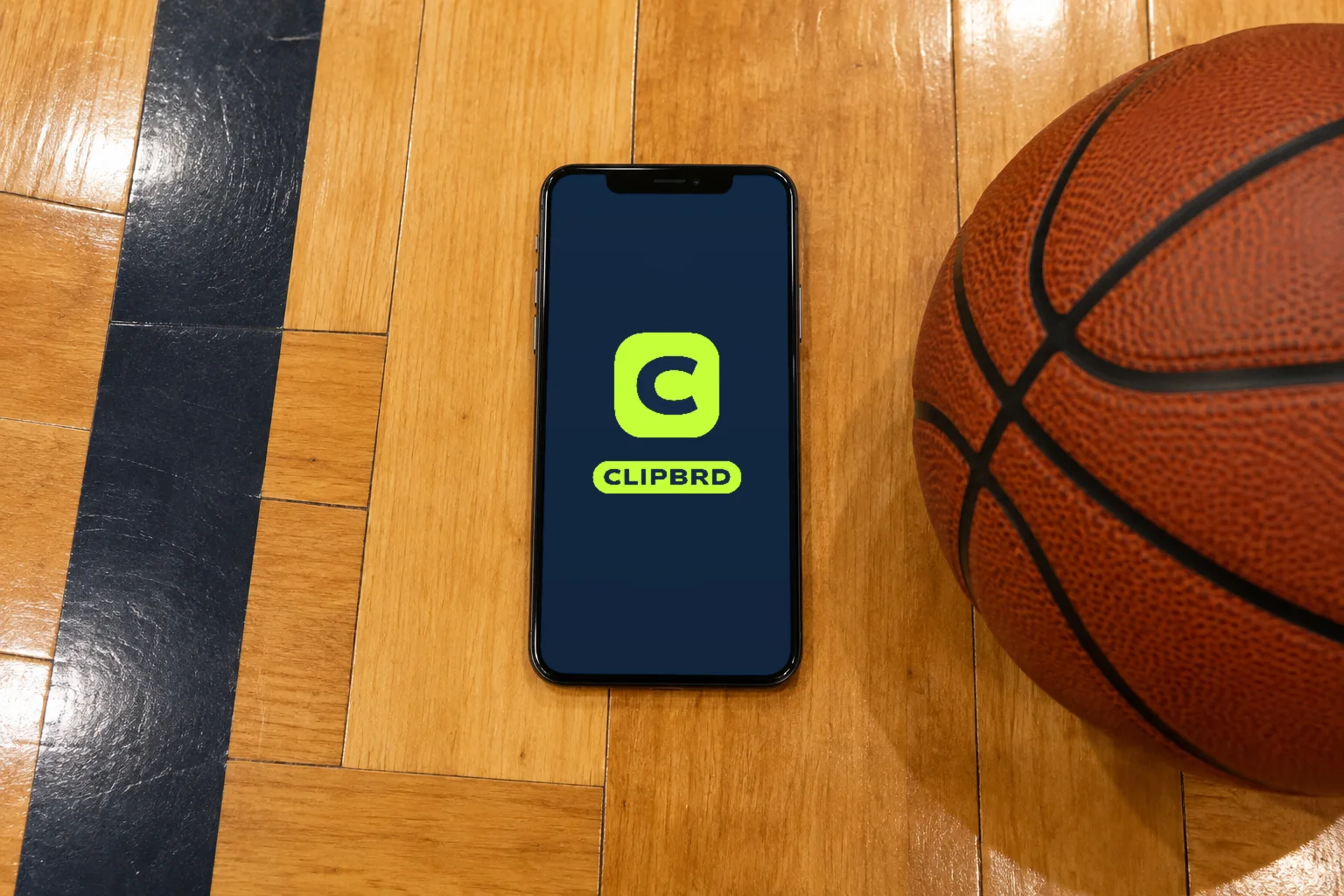 A phone on a gym floor showing the Clipbrd launch screen with the C app icon