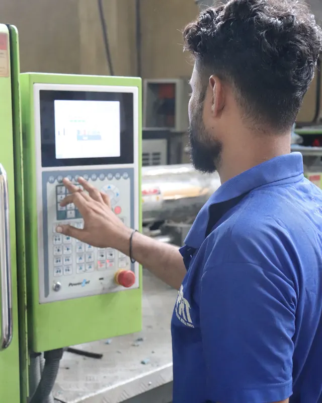 An operator entering a program at the control panel of a moulding machine