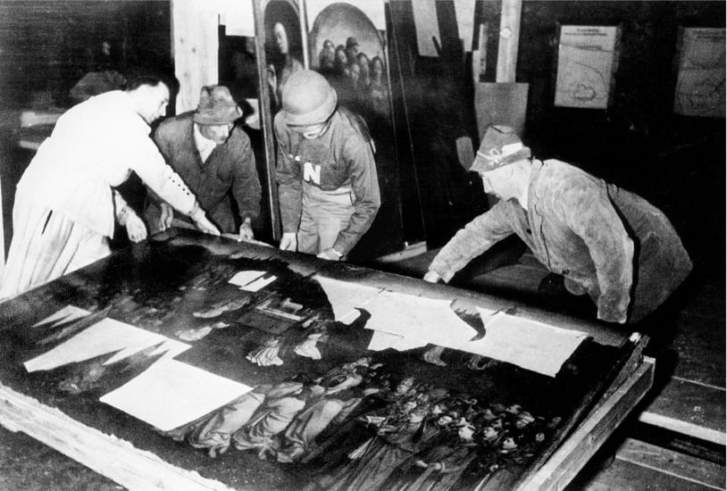 Workers lift the Ghent Altarpiece’s central panel from a crate inside the Altaussee mine in 1945.