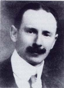 Black-and-white portrait of Arsène Goedertier wearing a collar and tie, with a dark moustache.