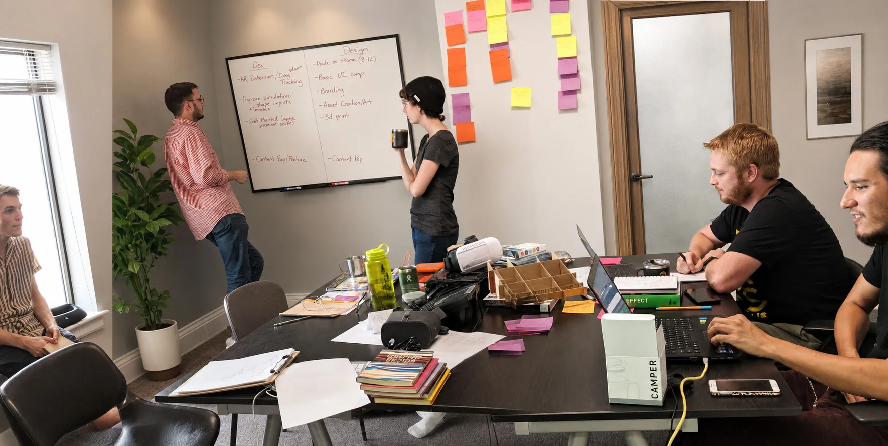 The Triptych team in a planning session, sprint notes on the whiteboard and laptops around the table.